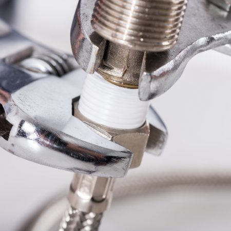 Plumber screwing plumbing fittings, closeup